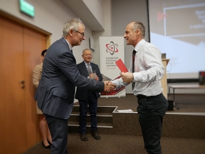 dr hab. Michał Gierlik, prof. NCBJ, reprezentant zespołu dr Łukasza Janiaka, podczas wręczania dyplomu 